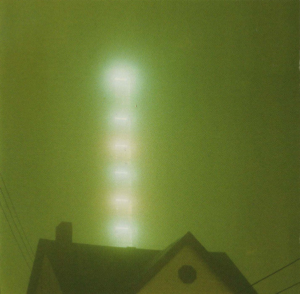 Foggy night scene with a lighthouse silhouette and green tinted sky.