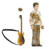 A collectible action figure of a young man with brown hair, wearing a white t-shirt and gray pants covered in brown mud splatters, shown alongside a matching orange electric guitar with a black strap and a separate brown headpiece on a white background.