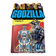 Packaged toy figure of Godzilla with colorful cityscape background