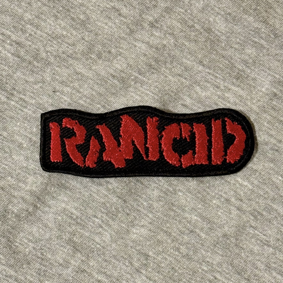 Embroidered patch with 'Iron Maid' text on a gray fabric background