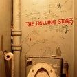 Toilet with 'The Rolling Stones' graffiti on a wall with various writings and drawings.