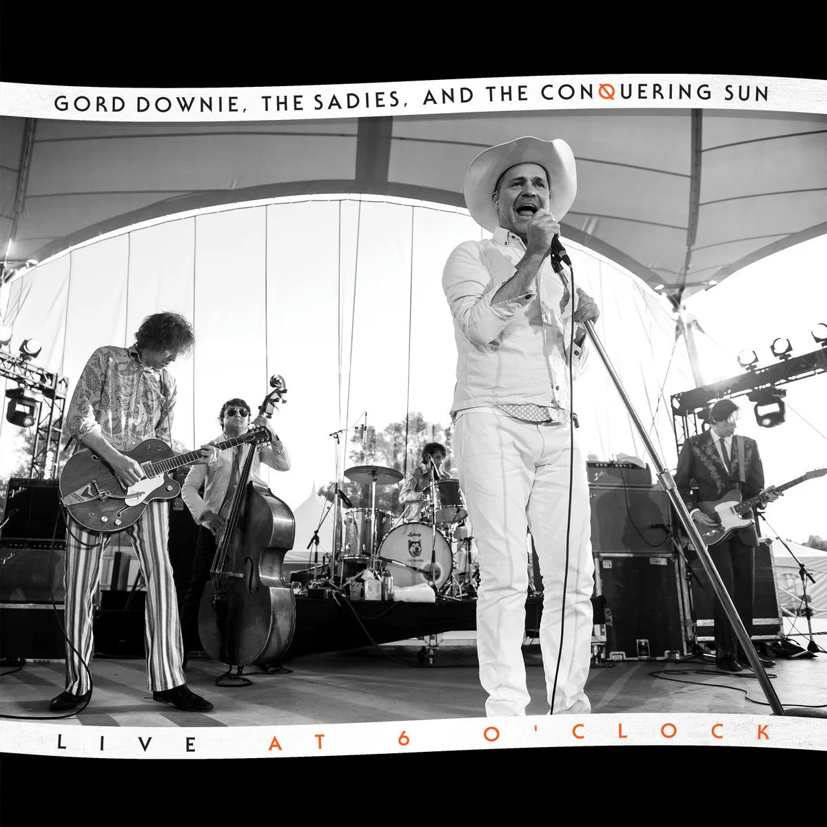Black and white photo of a band performing on stage with text overlay.