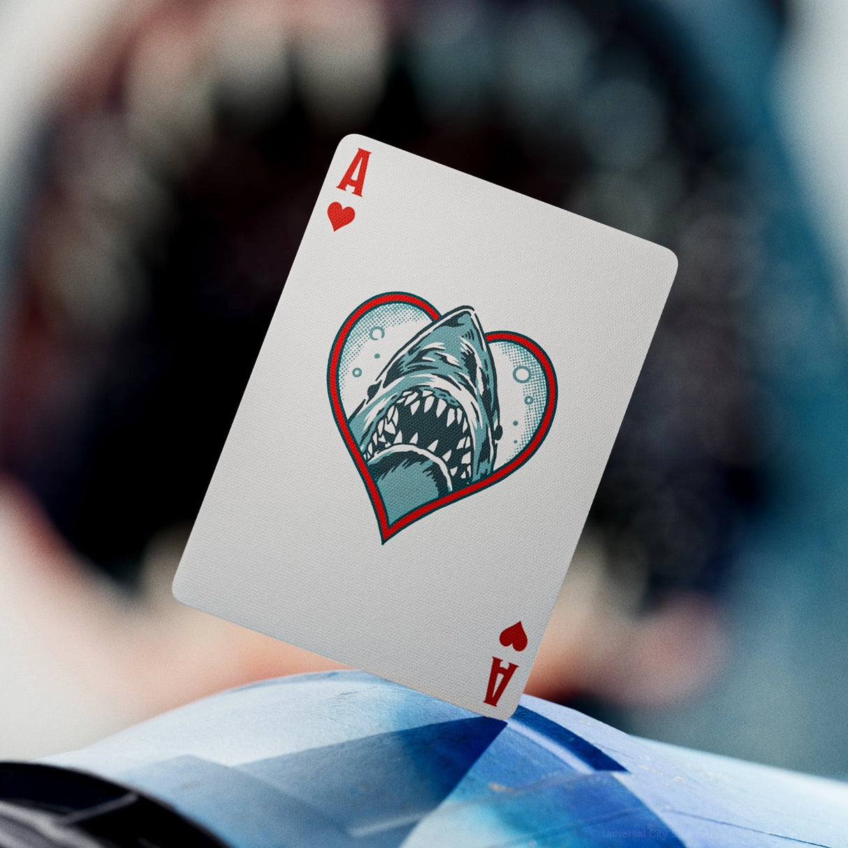 Playing card with shark design on a blurred background