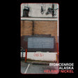 Album cover art for BigMCenroe's 'Helium / Nickel' featuring a vertical photograph of a brick building wall with a boarded window, graffiti, and utility wires, framed by black borders with white and red text at the bottom.