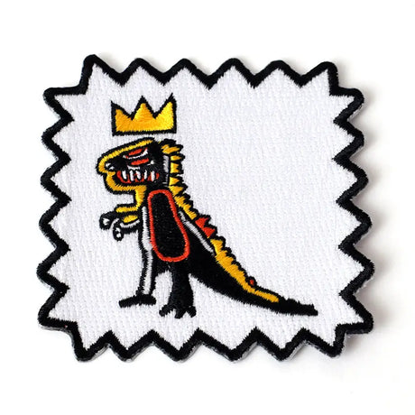Embroidered patch of a lizard with a crown on a white background