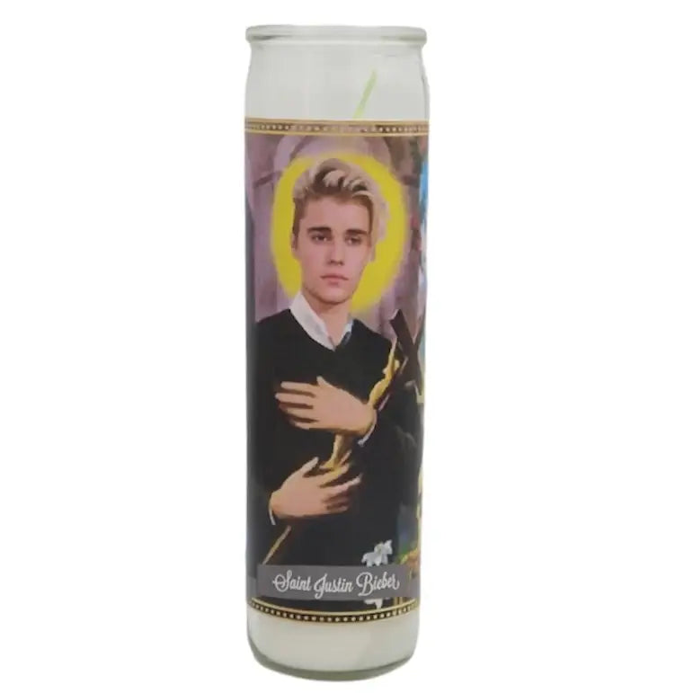 Candle with an illustration of a person wearing a black robe and yellow halo on a white background