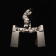 Person in a reflective suit with a helmet on a stand against a black background