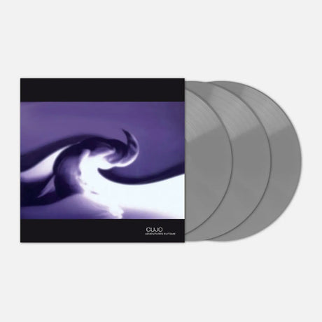 A vinyl record package shown on a light gray background, featuring a square album cover with a purple abstract design and three translucent silver records partially pulled from the sleeve.
