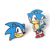 Two Sonic the Hedgehog enamel pins on a white background, one showing a close-up of Sonic's head and the other showing a full-body view of Sonic pointing upward.