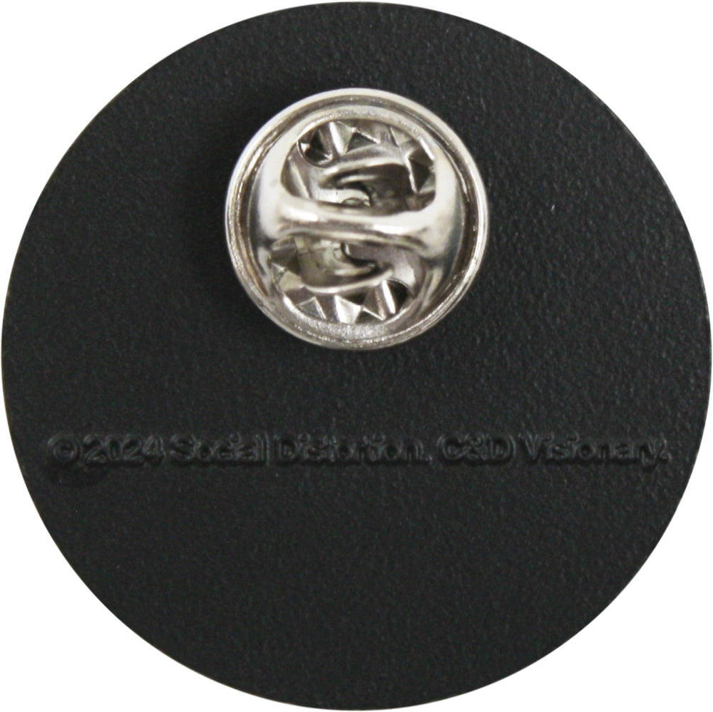 A silver metal pin with a textured, faceted starburst-like center, mounted on a round black backing card.