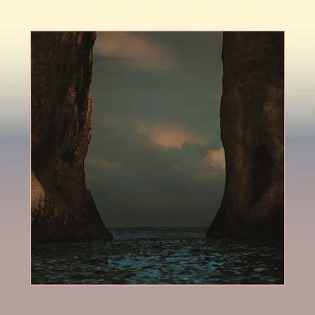 A square art print depicting a dramatic seascape with two towering dark rock cliffs framing a cloudy sky over dark blue water, centered on a soft beige-to-pink gradient background.