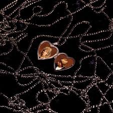 Heart-shaped earrings with a face design on a dark background