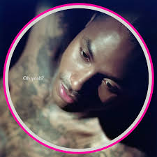 A circular close-up portrait of a man with a dark background and a bright pink ring border around the edge. The photo is low-resolution and somewhat blurry, with a watermark reading 'Oh yeah!'.
