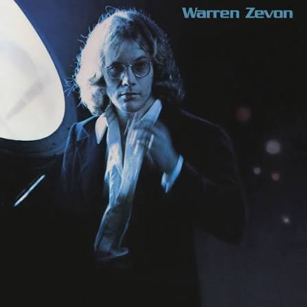 Album cover for Warren Zevon, featuring a blue-toned portrait of a person with glasses and a dark jacket against a dark background, with the text 'Warren Zevon' in the top right.