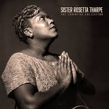 Sister Rosetta Tharpe with a guitar, looking upwards, on a dark background.