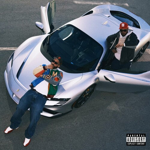 Two people interacting with a futuristic vehicle on a road, with a 'Parental Advisory Explicit Content' label.