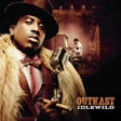 Album cover art for Outkast's 'Idlewild', featuring a close-up portrait of a man in a brown fedora and fur coat holding a vintage microphone, with a smaller scene of a pianist in the background.