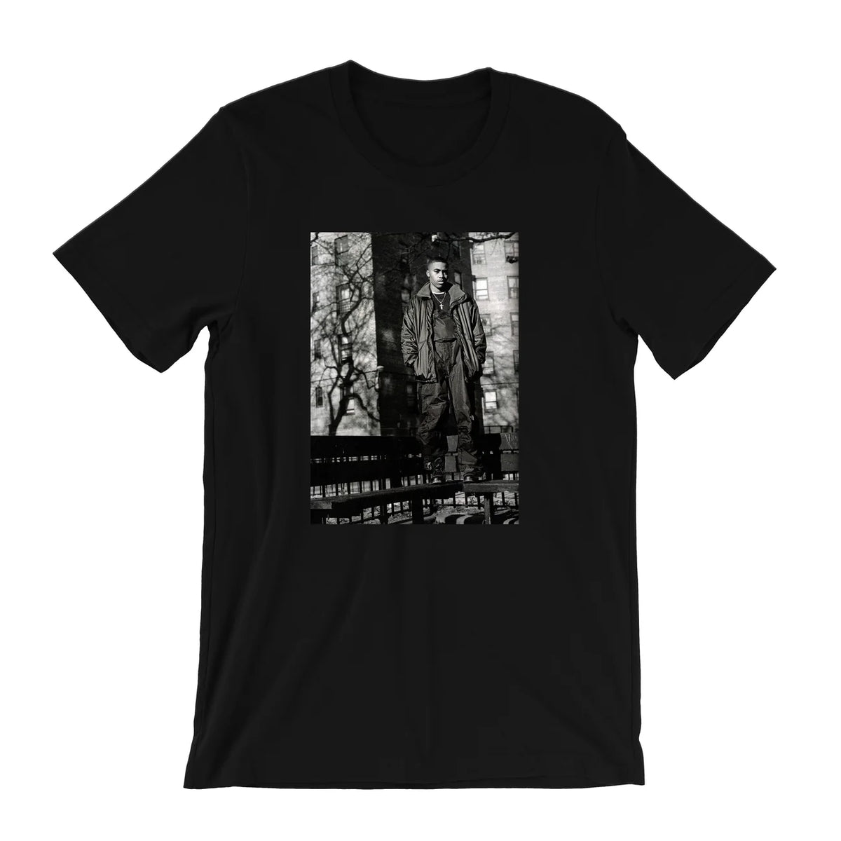 A black short-sleeve crewneck t-shirt featuring a rectangular black-and-white graphic print on the front, depicting a figure in a trench coat standing in front of a brick wall.