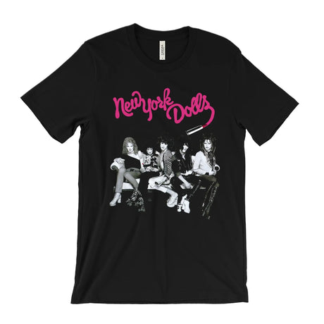 A black short-sleeve graphic t-shirt featuring the pink 'New York Dolls' band logo and a black-and-white photo print of the band members on the front, displayed against a solid white background.