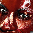 A close-up of a person's face covered in dark red liquid, with intense eyes visible and a Parental Advisory label in the bottom-right corner.