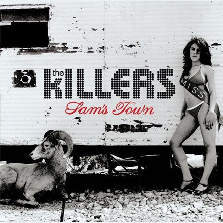 The image features a promotional photo of The Killers' album 'Sam's Town' with a backdrop that includes a rustic, weathered structure and a ram. The band's name is displayed in a stylized font, and the album title 'Sam's Town' is shown in large, bold letters below the band's name.