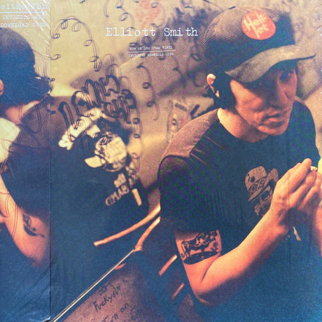 The image shows the back cover of the 'Either/Or' LP by Elliott Smith. It features a mirrored background with graffiti and the artist's reflection.